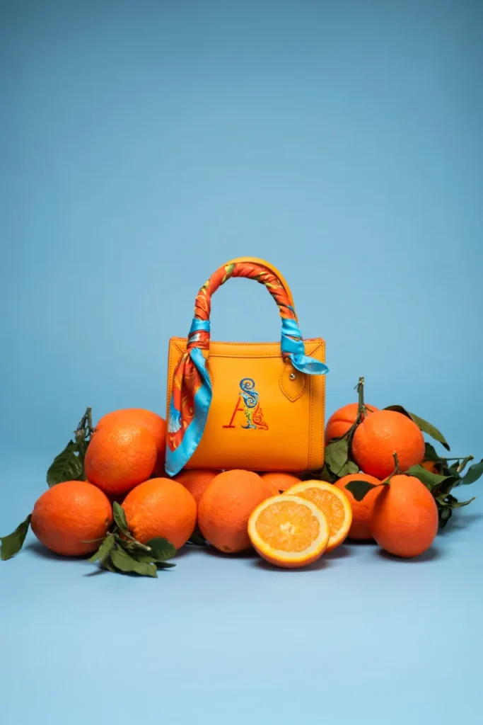 Mini Bag by Ammia in Ohoskin Salina, Arancia Bionda orange vegan leather handbag with embroidered A monogram and silk scarf tied to the handle